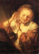 REMBRANDT Harmenszoon van Rijn, Young Woman Trying on Earrings